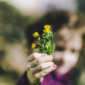 Blurred girl showing wild flowers | Alfredo Cuadros Laos